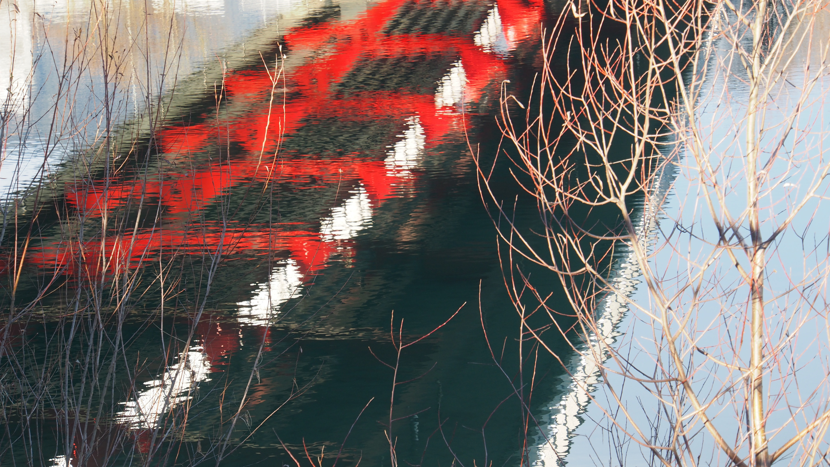 Spiegelung einer roten Brücke auf ruhigem Wasser